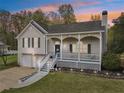 Exterior home elevation with front porch and lovely landscaping at dusk at 106 Thornwood Dr, Woodstock, GA 30188