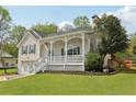 Charming home featuring a covered front porch, well-manicured lawn, and attached two-car garage at 106 Thornwood Dr, Woodstock, GA 30188