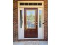 Inviting front door with glass panes, decorative sidelights, a brick surround, and a welcome mat at 3627 Mcclaren Way, Lawrenceville, GA 30044