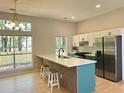 Bright, airy kitchen featuring a large island, stainless steel appliances, and stylish white and green cabinets at 6213 Marbut Farms Chase, Lithonia, GA 30058