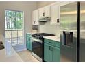 Stylish kitchen features a stainless steel refrigerator, oven, and sleek green cabinets with modern white backsplash at 6213 Marbut Farms Chase, Lithonia, GA 30058
