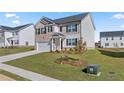 Charming two-story home boasts a siding and brick exterior, complemented by a well-manicured lawn and an attached two-car garage at 166 Aster Avenue, Locust Grove, GA 30248