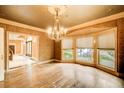 Formal dining room featuring an elegant chandelier, hardwood floors, and bay windows overlooking the garden at 305 Heards Ferry Rd, Atlanta, GA 30328