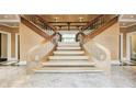 Elegant grand staircase featuring wood banisters and marble floors, creating a luxurious and inviting entry at 305 Heards Ferry Rd, Atlanta, GA 30328