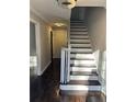 Inviting foyer features hardwood floors, a staircase with white risers, and a modern light fixture at 4844 Fairforest Dr, Stone Mountain, GA 30088