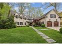 Charming white brick home with lush front lawn, walkway, and an attached two-car garage at 4431 Skyland Ne Dr, Atlanta, GA 30342