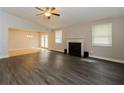Spacious living room featuring hardwood floors, a fireplace, and a ceiling fan at 8404 Park Ridge Ln, Riverdale, GA 30274
