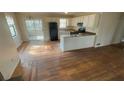 Open kitchen features white cabinets, appliances, and an eat-in bar overlooking the living area at 99 Fox Ridge Ct, Dallas, GA 30157