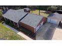 Aerial view of a red brick single story home with a detached two-car garage and extra storage at 2533 Whispering Pines Dr, Grayson, GA 30017