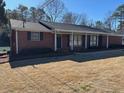 Charming single-story red brick home featuring a well-manicured lawn and mature landscaping at 2533 Whispering Pines Dr, Grayson, GA 30017