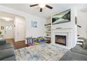 Bright living room featuring fireplace, ceiling fan, and open floor plan at 6415 Shalks Crossing Dr, Lithonia, GA 30058