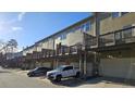 Townhomes with balconies, garage parking, and additional street parking against a backdrop of a clear blue sky at 3084 Turman Cir, Decatur, GA 30033