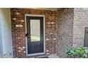 Inviting brick front door featuring a black door, a modern house number, and manicured greenery at 3084 Turman Cir, Decatur, GA 30033