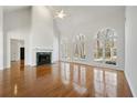 Bright living room with a fireplace, hardwood floors, and large arched windows with lots of natural light at 4185 Waterford Dr, Suwanee, GA 30024