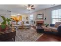 Cozy living room with hardwood floors, fireplace, a plush sectional sofa, and large windows providing natural light at 3184 Elmwood Ct, Atlanta, GA 30349