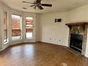 Living room featuring wood floors, a fireplace with stone accents, and large windows at 3628 Hopkins Ct, Powder Springs, GA 30127