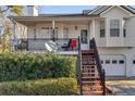 A cozy front porch with black railings, steps to the front door, and lush greenery, offering curb appeal at 674 Fairview Dr, Dallas, GA 30157