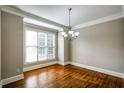 Bright dining room featuring hardwood floors, a modern chandelier, and a large window at 7 Chief Matthews Rd # 2A, Decatur, GA 30030