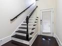 Elegant staircase with black and white accents leading to a door with blinds at 745 Fountainhead Ne Ln # 112, Atlanta, GA 30324