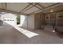 Open carport with a covered roof attached to the house and a detached garage nearby at 1395 Winburn Dr, East Point, GA 30344