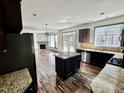 Open-concept kitchen with island, granite countertops, stainless steel appliances, and hardwood floors at 2499 Sinclair Trce, Powder Springs, GA 30127