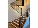 Elegant staircase with wood steps, decorative iron railings, and freshly painted walls at 2499 Sinclair Trce, Powder Springs, GA 30127