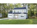 Charming two-story home with light green siding, a well-manicured lawn, and attached garage for modern living at 1276 Seattle Slew Ln, Norcross, GA 30093