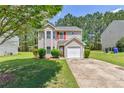 A lovely two-story home with neutral siding, neat landscaping, and a driveway, set on a green lawn at 2075 Ivy Ln, Union City, GA 30291
