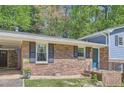 Close-up of a well-maintained home with brick facade, black shutters, and a charming front entrance at 1461 Sanden Ferry Dr, Decatur, GA 30033