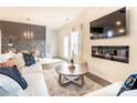 Well-lit living room featuring a modern fireplace and comfortable sofa with accent pillows at 149 Weldon Rd, Mcdonough, GA 30253