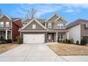 Charming two-story home featuring stone accents, a two-car garage, and a well-manicured lawn at 214 Gaston Ct, Canton, GA 30115