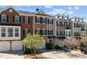 A row of townhomes featuring mixed brick and siding exteriors, garages and nicely maintained landscaping at 3972 Church View Ln, Suwanee, GA 30024