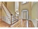 Light and airy foyer featuring hardwood floors, a staircase, and an arched doorway at 2165 Sugarstone Ct, Lawrenceville, GA 30043