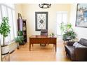 Cozy home office space with wooden floors, a leather chair, and lush greenery, creating a peaceful work environment at 2165 Sugarstone Ct, Lawrenceville, GA 30043