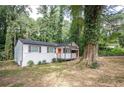 Inviting single-story home with charming gray porch, freshly painted brick foundation and lush greenery at 2437 Clarissa Nw Dr, Atlanta, GA 30318