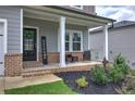 Inviting front porch with brick accents and cozy seating, complemented by manicured landscaping at 419 Murphy Ave, Canton, GA 30114
