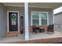 A welcoming front porch with stylish seating, brick accents, and a 