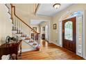 Inviting foyer with hardwood floors, a staircase with white railings, and a decorative glass front door at 9860 Hunt Club Way, Johns Creek, GA 30022