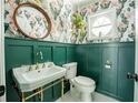 Charming powder room featuring stylish wallpaper, green wainscoting, and a vintage sink at 1477 Brawley Ne Cir, Brookhaven, GA 30319