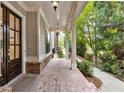 Inviting front porch boasts brick flooring and walkway surrounded by lush greenery at 201 Saddle Rd, Alpharetta, GA 30009