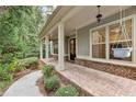 Welcoming front porch showcases brick accents and a charming porch swing at 201 Saddle Rd, Alpharetta, GA 30009