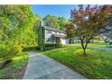 Charming home with gray siding and a well-manicured lawn surrounded by mature trees at 3988 Centennial Trl, Duluth, GA 30096