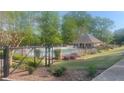 A tranquil community pool and lounging area surrounded by lush greenery and a secure fence at 209 Southerness Ct, Stockbridge, GA 30281