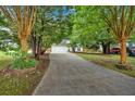 Long driveway leads to a charming home with a 2-car garage and lush landscaping, offering privacy and curb appeal at 209 Southerness Ct, Stockbridge, GA 30281