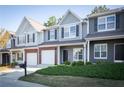 Charming townhome featuring a gray exterior, brick accents, attached garage, and manicured landscaping at 2162 Spikerush Way, Buford, GA 30519