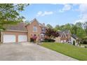 Charming two-story brick home with a well-manicured lawn, mature trees, and an attached two-car garage at 3025 Kaley Nw Dr, Kennesaw, GA 30152