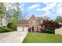 Charming two-story brick home with an attached two-car garage, beautiful shrubs, and a well-manicured lawn at 3025 Kaley Nw Dr, Kennesaw, GA 30152