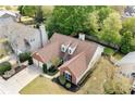 Aerial view of a home with mature landscaping, a two-car garage, and a well-maintained roof at 1483 Chamirey Sw Dr, Marietta, GA 30008