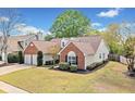Lovely home featuring brick accents, green lawn, and mature trees in a well-maintained neighborhood at 1483 Chamirey Sw Dr, Marietta, GA 30008
