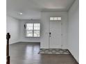 Bright entryway featuring hardwood floors and a white front door with a decorative rug at 5530 Bower Pl, Cumming, GA 30028